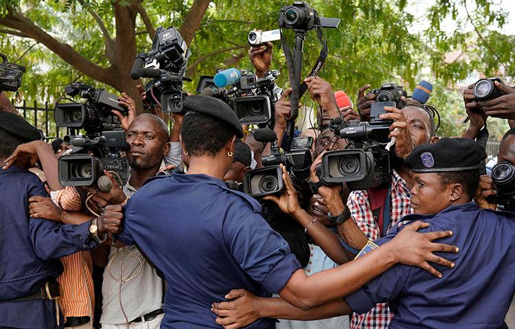 Congolese police officers hold back members of the media in Kinshasa, Democratic Republic of Congo, on January 12, 2019. Journalist Steeve Mwanyo Iwewe was recently fined and sentenced to one year in jail for insulting the governor of Équateur province. (Jerome Delay/AP)