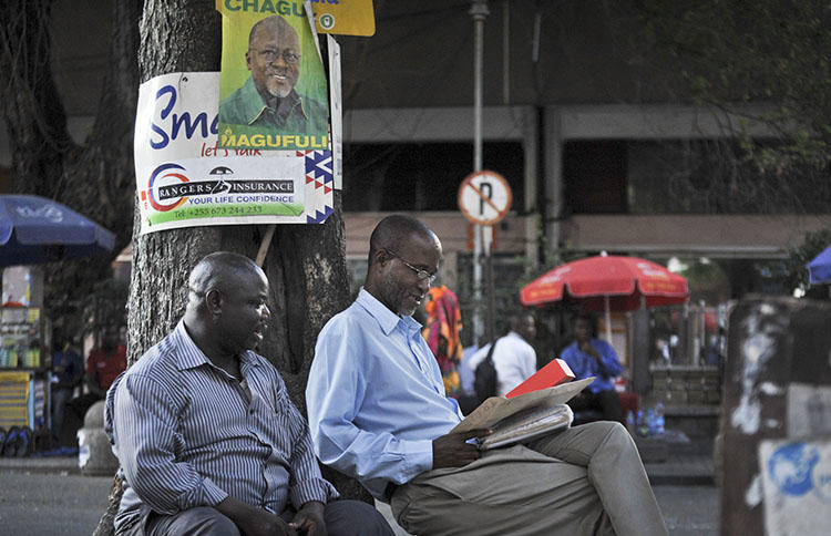 Tanzanians sit next to a tree in Dar es Salaam in 2015. Tanzanian authorities this week imposed a temporary ban on The Citizen over its reporting. (AP/Khalfan Said)