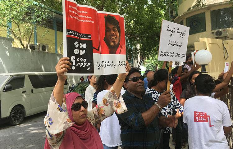 Fathimath Shehenaz holds a sign outside the Malé parliament in February, calling for justice for her brother, the blogger Ahmed Rilwan, who was abducted in 2014. (CPJ)
