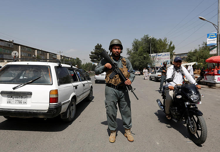 An Afghan police officer inspects vehicles at a checkpoint in Kabul on August 6, 2017. An Afghan journalist was recently killed when he was shot by two unidentified men in Khost. (Mohammad Ismail/Reuters)