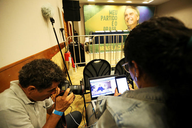 Jornalistas acompanham o Facebook Live de Jair Bolsonaro, legislador de extrema direita e candidato presidencial do Partido Social Liberal (PSL), no Rio de Janeiro, Brasil, em 7 de outubro de 2018. Depois de assumir o cargo em janeiro, Bolsonaro e seus partidários tornaram o trabalho dos jornalistas brasileiros mais difícil. (Reuters/Sergio Moraes)