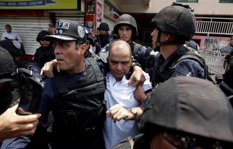 Policías arrestan al periodista David Romero en Tegucigalpa, Honduras, el 28 de marzo de 2019. La Corte Suprema sentenció en enero que el director de Radio Globo y Globo TV debe cumplir una de condena de 10 años por difamación. (Reuters/Jorge Cabrera)