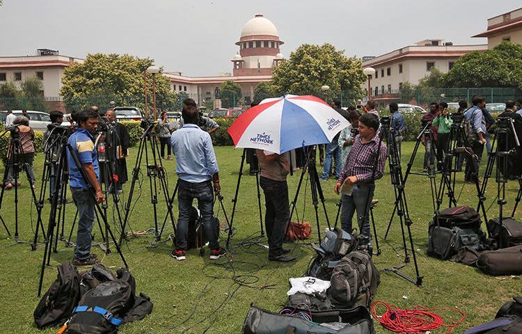 Television journalists are seen outside the premises of the Supreme Court in New Delhi, India, August 22, 2017. The Indian government threatened to invoke Official Secrets Act against two news outlets on March 6, 2019. (Reuters/Adnan Abidi)