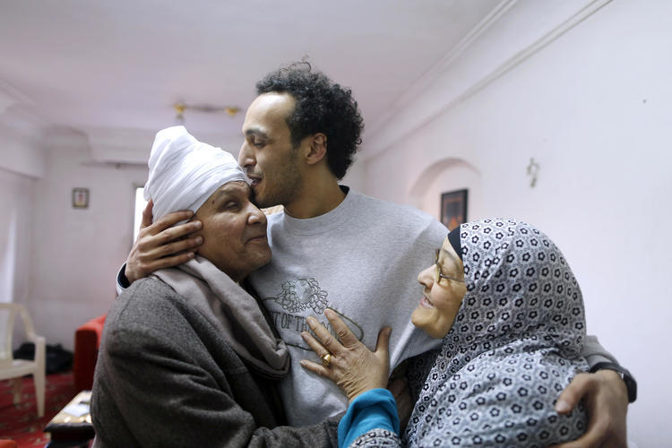 Egyptian photojournalist Mahmoud Abou Zeid, known as Shawkan, is hugged by his parents at his home in Cairo, Egypt, on March 4, 2019. (Amr Nabil/AP)