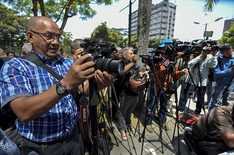 Periodistas cubren la liberación de cinco colegas detenidos brevemente en Caracas en enero. El número de detenciones arbitrarias de periodistas locales y extranjeros que cubren la crisis política y económica de Venezuela se está incrementando. (AFP/Juan Barreto)