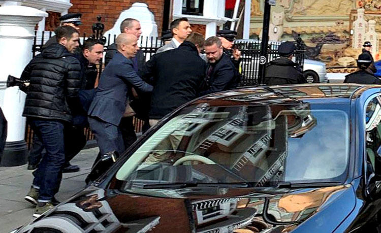 Metropolitan Police officers carry WikiLeaks founder Julian Assange during his arrest, following the Ecuadoran government's termination of asylum, in London on April 11, 2019. (Adrian Cotterill/Daily Dooh via Reuters)