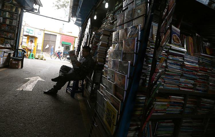 A man reads a newspaper at a market in Lima, in September 2018. A Peru court has ordered assets for Ojo Público and two journalists to be frozen. (Reuters/Mariana Bazo)