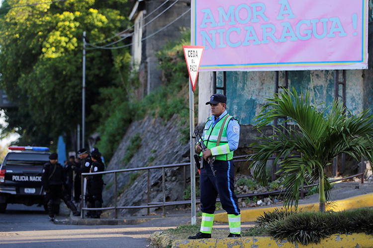 A police officer stands guard at the 100% Noticias offices in Managua, Nicaragua, on December 22, 2018. The trial of journalists Lucía Pineda and Miguel Mora was recently delayed without a new date set. (Reuters/Oswaldo Rivas)