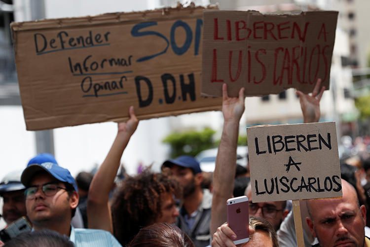 People hold placards reading "Free Luis Carlos" outside the office of Venezuela's attorney general in Caracas on March 12, 2019. The journalist was released later on March 12. (Reuters/Carlos Garcia Rawlins)