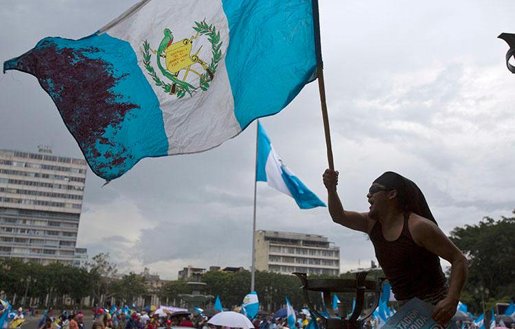 Un hombre ondea la bandera nacional de Guatemala durante una protesta en Ciudad de Guatemala. El país tiene previsto celebrar elecciones presidenciales y legislativas en Junio. (AP/Moisés Castillo, archivo) (AP/Moises Castillo, File)