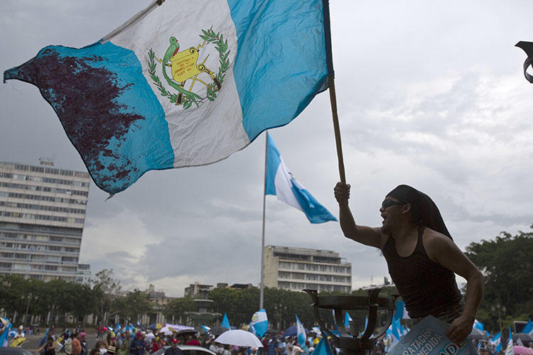 Un hombre ondea la bandera nacional de Guatemala durante una protesta en Ciudad de Guatemala. El país tiene previsto celebrar elecciones presidenciales y legislativas en Junio. (AP/Moisés Castillo, archivo) (AP/Moises Castillo, File)