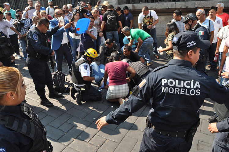 An injured man receives first aid after a gunman opened fire, killing two and injuring a journalist, in the central square of Cuernavaca, Morelos state, in Mexico on May 8, 2019. (AFP/STR)