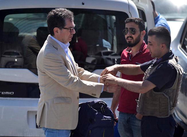 Kadri Gürsel, left, is handcuffed by police outside an Istanbul prison on May 29. Gürsel, a former columnist for Cumhuriyet, and Turkey chair of the International Press Institute, was freed later that day. (AP/DHA)