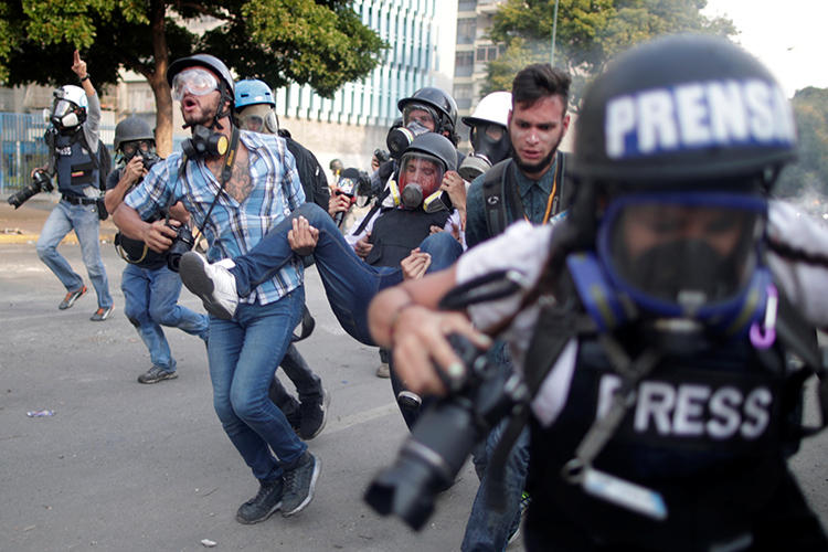 Un trabajador de la prensa herido es cargado durante una protesta contra el gobierno del Presidente Nicolás Maduro y para conmemorar el día del trabajador en Caracas, Venezuela, el 1ero de mayo, de 2019. (Reuters/Ueslei Marcelino)