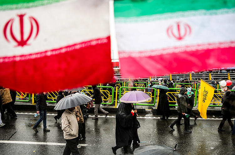 People carry umbrellas in Tehran, Iran, on February 11, 2019. On May 1, two journalists were arrested while covering Labor Day demonstrations in Tehran. (Vahid Ahmadi/Tasnim News Agency via Reuters)