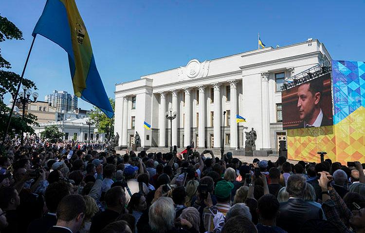 People gather in front of the Ukrainian parliament during the inauguration on May 20, 2019, of President Volodymyr Zelenskiy, who campaigned on an anti-corruption platform. Cherkasy-based journalist Vadym Komarov, known for reporting on local corruption, died June 20 as the result of an assault six weeks earlier. (AP/Evgeniy Maloletka)