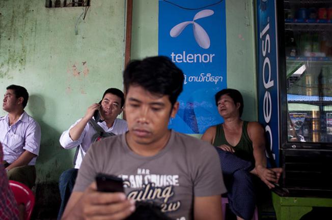 A man uses a cellphone in Yangon, Myanmar, on September 26, 2014. The government recently cut mobile internet access to Rakhine and Chin states. (AFP/Ye Aung Thu)