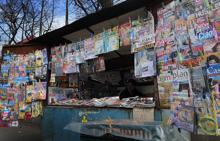 A man waits for customers in a news kiosk in Bucharest, Romania, on March 22, 2011. Romanian investigative journalist Diana Oncioiu received an anonymous death threat on June 11, 2019. (AFP/Daniel Mihailescu)