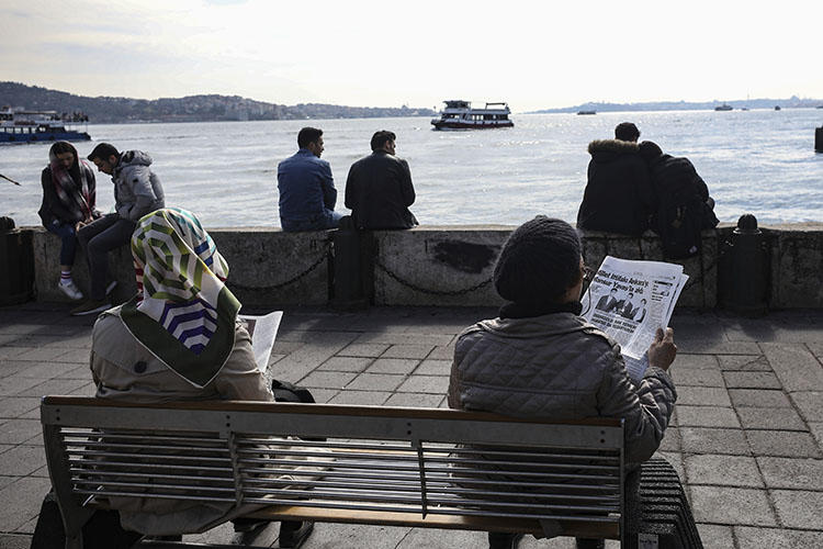 People read papers by the Bosporus in Istanbul in April 2019. A journalist this week started a prison sentence for insulting Turkey's president in a speech. (AP/Emrah Gurel)