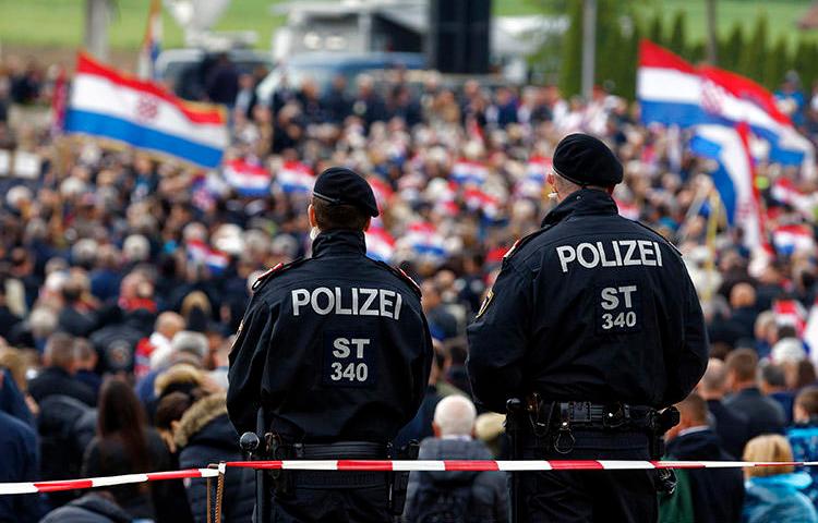 Austrian police, pictured at a World War II memorial in Bleiburg on May 18, 2019, that was attended by thousands of Croatian far-right supporters. A Croatian journalist says he was harassed and assaulted during the event. (AP/Darko Bandic)
