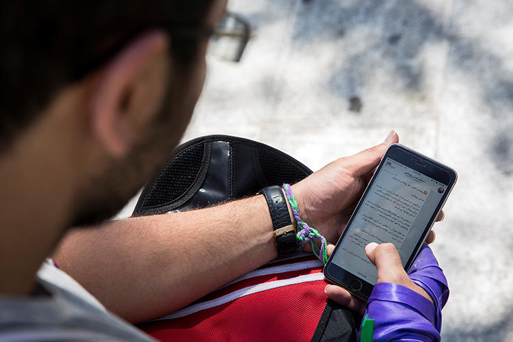 A man uses his smartphone to follow election news in Tehran, Iran, May 17, 2017. Iran charged four Telegram news channel Gam reporters over labor coverage, it was reported June 11. (Reuters/TIMA)