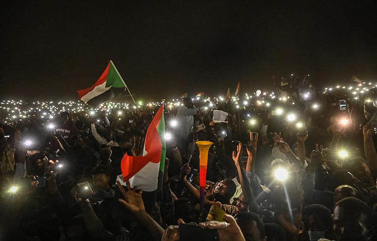 Sudanese protesters are seen with their smartphones in Khartoum on April 21, 2019. CPJ has called on South African telecommunications company MTN Group to end its role in Sudan's internet shutdowns. (AFP/Ozan Kose)