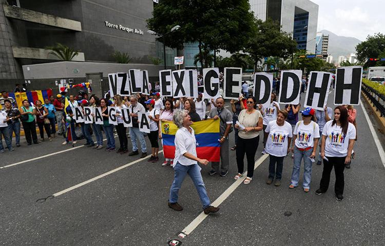 Opositores manifiestan fuera de la sede del Programa para el Desarrollo de las Naciones Unidas durante la visita de la Alta Comisionada de las Naciones Unidas para Derechos Humanos, Michelle Bachelet, en Caracas, el 21 de junio de 2019. El periodista venezolano Braulio Jatar fue liberado condicionalmente de su arresto domiciliario el 8 de julio de 2019 y tiene prohibición de salida del país. (AFP/Cristian Hernandez)