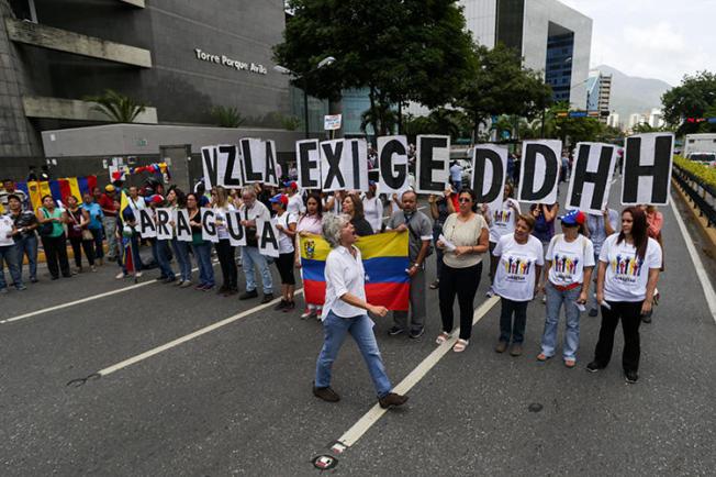 Opositores manifiestan fuera de la sede del Programa para el Desarrollo de las Naciones Unidas durante la visita de la Alta Comisionada de las Naciones Unidas para Derechos Humanos, Michelle Bachelet, en Caracas, el 21 de junio de 2019. El periodista venezolano Braulio Jatar fue liberado condicionalmente de su arresto domiciliario el 8 de julio de 2019 y tiene prohibición de salida del país. (AFP/Cristian Hernandez)