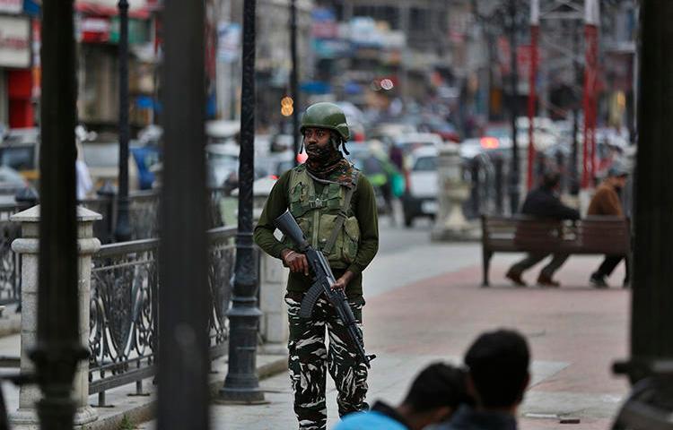 An Indian paramilitary soldier stands guard in Srinagar, Indian-controlled Jammu and Kashmir, on June 12, 2019. India's National Investigation Agency questioned Greater Kashmir editor Fayaz Kaloo for six days in early July. (AP Photo/Mukhtar Khan)