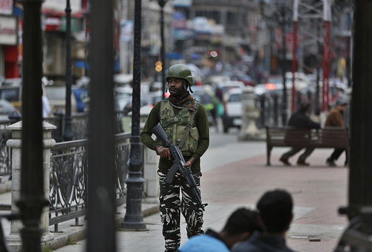 An Indian paramilitary soldier stands guard in Srinagar, Indian-controlled Jammu and Kashmir, on June 12, 2019. India's National Investigation Agency questioned Greater Kashmir editor Fayaz Kaloo for six days in early July. (AP Photo/Mukhtar Khan)