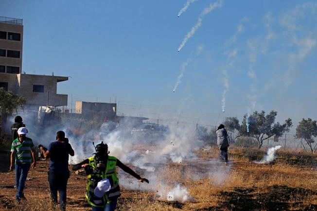 Journalists and demonstrators are seen in the West Bank on July 20, 2019. On July 19 and 20, at least three Palestinian journalists were injured by Israeli soldiers while covering protests in Gaza and the West Bank. (Reuters/Mussa Qawasma)