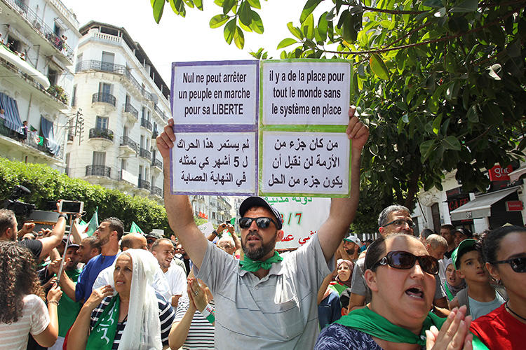 A man holds a placard reading "no one can stop a people marching for his freedom" as Algerian protesters demonstrate in Algiers on July 26, 2019. Access to at least five independent local news websites has been interrupted in recent weeks amid the protests. (AFP)