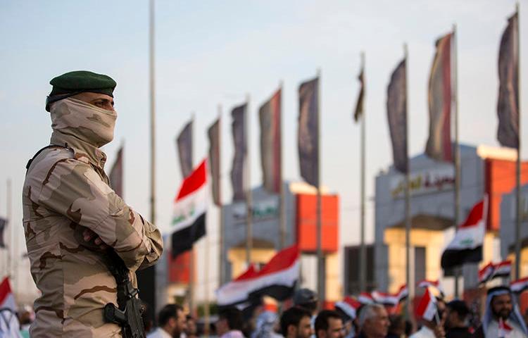 A member of the Iraqi security forces stands guard outside the Basra local government headquarters on July 19, 2019, as protesters gather for a demonstration. Basra police attempted to arrest Iraqi reporter Hassan Sabah in a raid on his home in Basra on July 23. (AFP/Hussein Faheh)