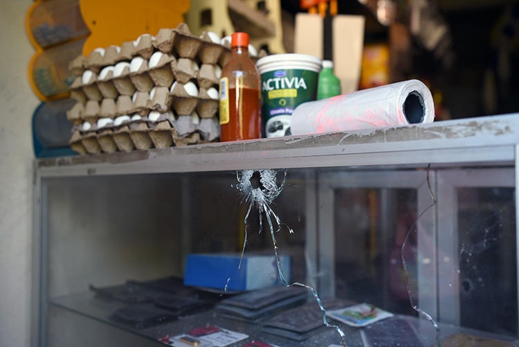 A bullet hole is seen at a grocery store belonging to Jorge Celestino Ruiz Vázquez, who was shot dead in Veracruz state on August 2. Ruiz, a reporter for El Gráfico, is the third journalist killed in one week in Mexico. (AFP/Victoria Razo)