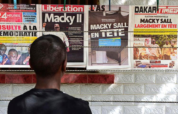 A man looks at newspaper front pages in Dakar, on February 25, 2019, one day after Senegal's presidential elections. Senegalese authorities arrested critical journalist Adama Gaye on July 29. (AFP/Seyllou)