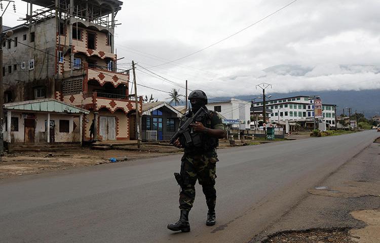 A Cameroonian elite Rapid Intervention Battalion member walks along an empty street in the city of Buea in Cameroon's Anglophone southwest region on October 4, 2018. Cameroon’s military detained pidgin news anchor Samuel Wazizi on August 2, 2019, in Buea. (Reuters/Zohra Bensemra)