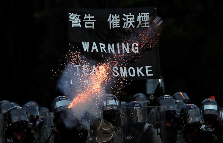 Police fire tear gas during protests in Hong Kong on August 5. A video journalist was knocked unconscious after being hit in the head by a tear gas canister while covering unrest in the Sham Shui Po district. (Reuters/Tyrone Siud)