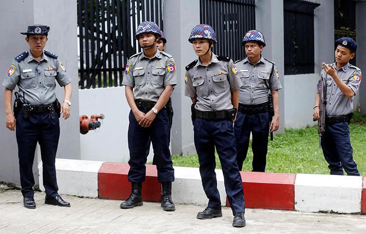 Police stand guard outside a court in Yangon, Myanmar, on August 9, 2019. The Mandalay District Court recently agreed to hear an appeal that could reopen a criminal defamation lawsuit against editor Swe Win. (Reuters/Ann Wang)