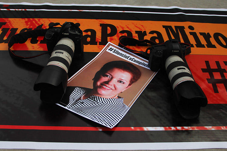 Cámaras y una foto de Miroslava Breach son dejadas como parte de un tributo a la periodista en el marco del segundo aniversario luctuoso de su asesinato. Un informe ha señalado las fallas en la investigación mexicana de su homicidio.(AFP/Herika Martinez)