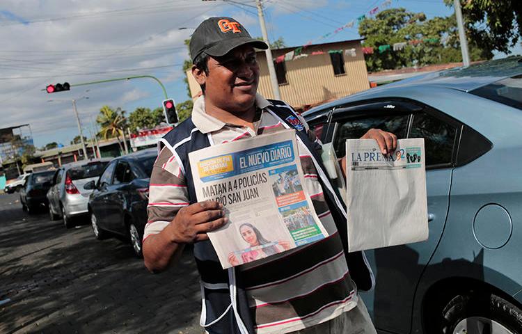 Un vendedor de periódicos vende “La Prensa” y ‘El Nuevo Diario” el 18 de enero de 2019. Autoridades aduaneras han retenido tinta e papel de prensa para ambos diarios desde agosto de 2018. (AFP/Inti Ocon)