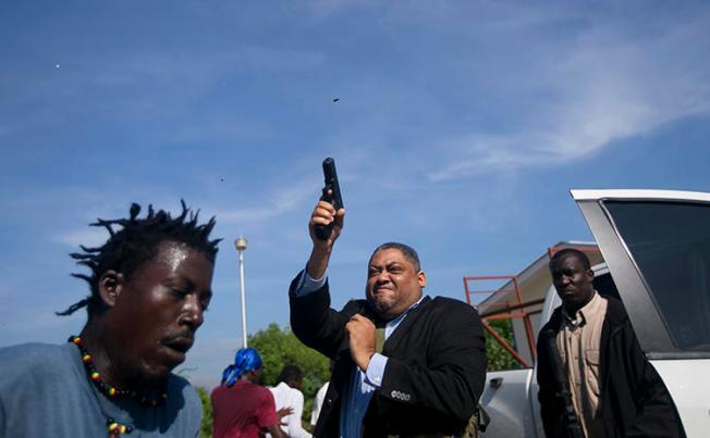 Senator Jean Marie Ralph Féthière fires his gun in Port-au-Prince, Haiti, on September 23, 2019. AP photographer Chery Dieu-Nalio was shot in the incident. (AP/Chery Dieu-Nalio)