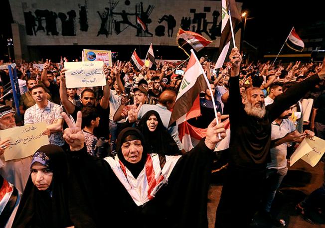 Iraqi protesters chant slogans during a demonstration in Tahrir Square in central Baghdad, Iraq, on June 21, 2019. Iraq suspended U.S.-funded broadcaster Al-Hurrah for 3 months over a corruption report on September 2. (AP Photo/Hadi Mizban)