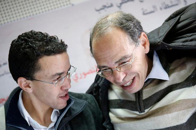 Maati Monjib, right, chats with Moroccan journalist Hicham Mansouri in Rabat, Morocco, January 17, 2016. Amnesty International reported this month that Monjib has been sent malicious messages in an attempt to install spyware on his phone. (AP Photo/Abdeljalil Bounhar)