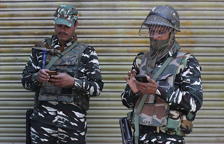 Indian paramilitary soldiers use their cellphones in Srinagar, Indian controlled Kashmir, on October 14, 2019 after the partial lifting of a communications lockdown in place since India's government downgraded the region's semi-autonomy in August. (AP Photo/Mukhtar Khan)
