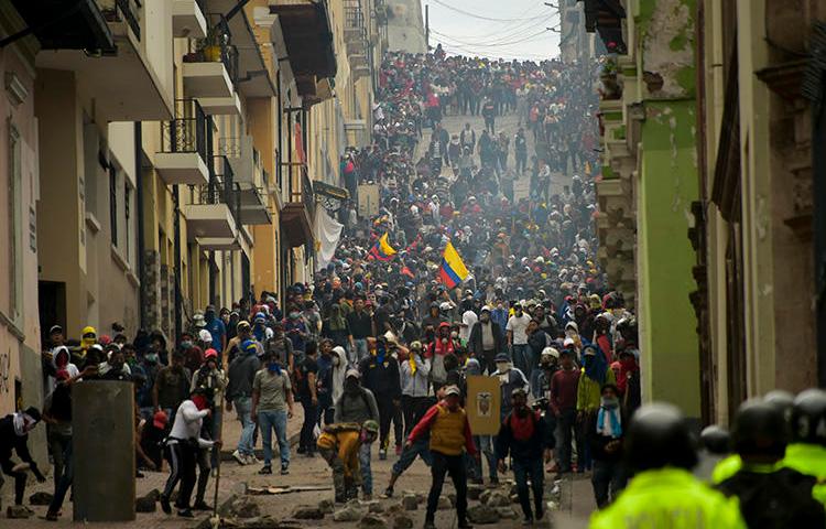 Manifestantes se enfrentan con la policía antidisturbios en Quito, mientras miles marchan contra la decisión del presidente ecuatoriano, Lenín Moreno, de recortar los subsidios al combustible, el 9 de octubre de 2019. Tanto las autoridades como los manifestantes han atacado a la prensa en medio de las protestas. (AFP/Rodrigo Buendia)