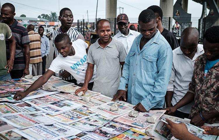 People look at front pages at a newspaper stand in Port Harcourt, after Nigeria's presidential election results were announced on February 27, 2019. Nigerian police beat two Inspiration FM journalists after covering a protest in Uyo, in Akwa-Ibom State, on September 24, 2019. (AFP/Yasuyoshi Chiba)