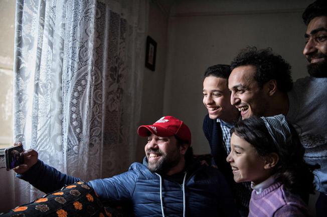 The Egyptian photojournalist Mahmoud Abu Zeid, second right, known as Shawkan, poses for a selfie at his home in Cairo on March 4, 2019. As part of the restrictive terms of his release from prison, the journalist has to spend each night at a police station. (AFP/Khaled Desouki)