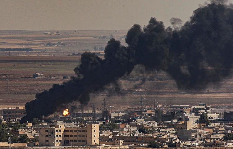 Smoke is seen billowing from the sites of air strikes in Ras al-Ayn, Syria, on October 13, 2019. Syrian Kurdish journalist Saad Ahmed was killed in an airstrike in the town. (AP/Emrah Gurel)