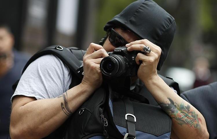 A photographer takes pictures of a protest against the murder and disappearances of journalists in Mexico, in Mexico City on August 21, 2019. (AP/Rebecca Blackwell)