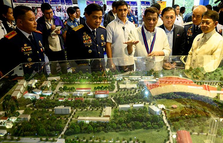 Philippine President Rodrigo Duterte (C) gestures as he looks at the diorama of the new Philippine National Police Academy during the 118th anniversary of the service, at the Camp Crame headquarters in Manila on August 9, 2019. A radio journalist was killed in the central Philippines on November 7, 2019. (AFP/Noel Celis)